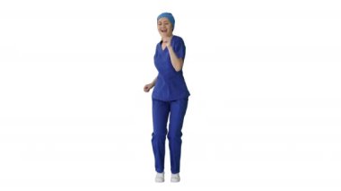 Mavi üniformalı, gülümseyen kadın doktor beyaz arka planda dans ediyor ve tezahürat yapıyor..
