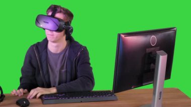 Oyuncu çocuk yeşil ekranda VR kulaklıkla oynuyor, Chroma Key.