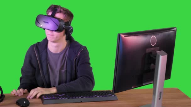 Gamer niño jugando con auriculares VR en una pantalla verde, Chroma Key. — Vídeo de stock