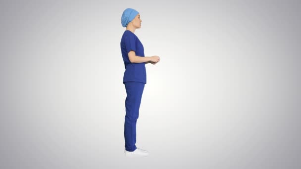 Mavi üniformalı kadın doktor, değişken arka planda tıbbi bakım hakkında konuşuyor.. — Stok video
