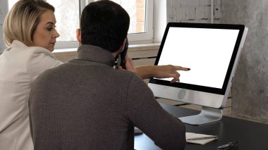 Genç çift monitörden konuşuyor. Adam telefon eder. Beyaz