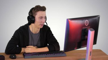 Genç oyuncu gradyan arka planda bir video görüşmesi yapıyor.