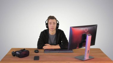 Kulaklık takmış genç bir adam kameraya gradyan sırt hakkında konuşma yapıyor.