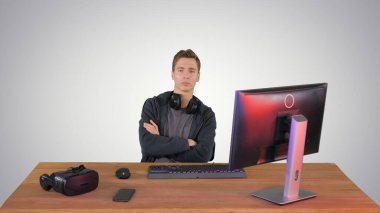 Kendine güvenen oyuncu kameraya bakıyor ve elleri çapraz eğik.