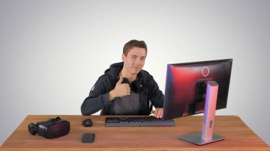 Genç oyuncu başparmağını kaldırıyor ve gradideki kameraya bakıyor.