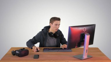 Kulaklıklı oyuncu bilgisayarda oyun oynuyor ve...