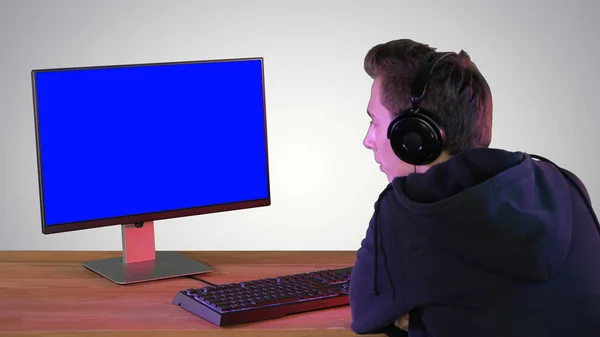 Professionele Gamer op zoek naar zijn personal computer op gradiënt — Stockfoto