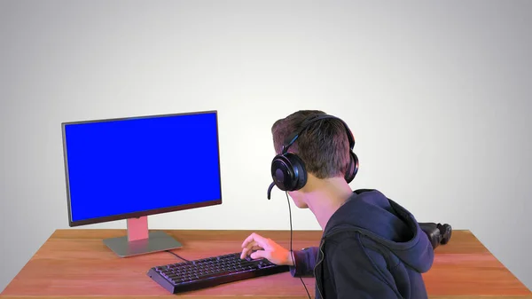 Gamer talking about the game on the screen to camera on gradient — Stock Photo, Image