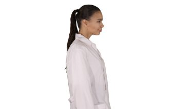 Beyaz önlüklü doktor beyaz arka planda yürüyor.