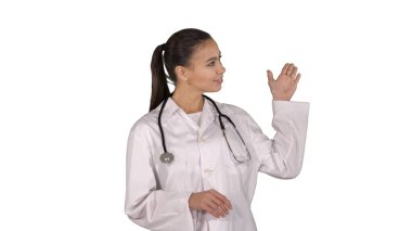 Kadın doktor elleriyle sunum yaptığı bir şeyi gösteriyor.