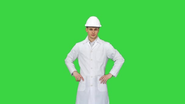 Um jovem engenheiro colocando chapéu de alvoroço em uma tela verde, Chroma Key. — Vídeo de Stock