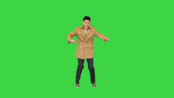 Молодой человек в плаще танцует и веселится на зеленом экране, хрома ключ. — стоковое видео