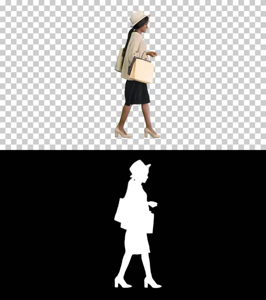 Χαρούμενη Αφροαμερικανή γυναίκα με καπέλο και πλεκτά να περπατά με sh — Φωτογραφία Αρχείου