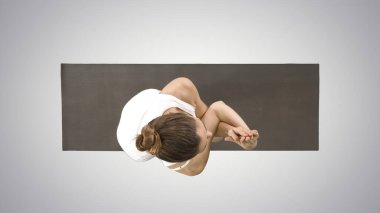 Güzel genç bir kadın ayak bilekleri, baldırları için yoga egzersizi yapıyor.