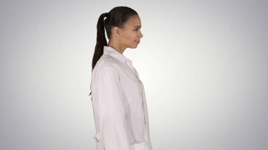 Beyaz bornozlu doktor arkası dönük bir şekilde yürüyor.