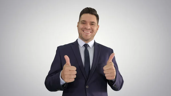 Happy business man holding thumbs up on gradient background. — Stock Photo, Image