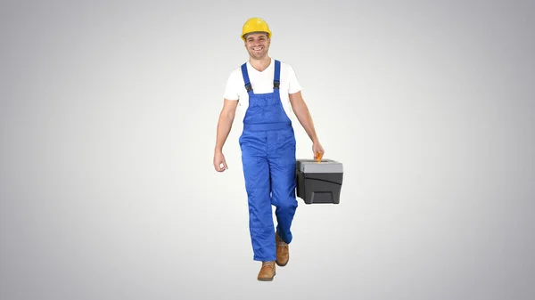 Builder with tool case walking on gradient background. — Stock Photo, Image