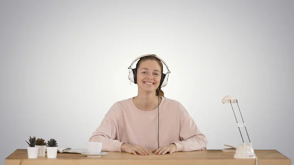 Preciosa dama en jersey rosa escuchando música en auriculares y — Foto de Stock