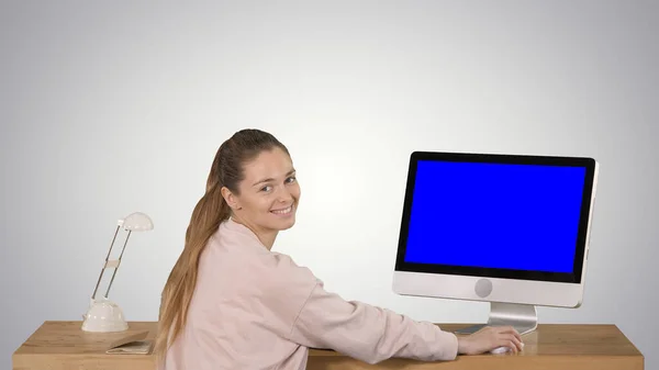 Mujer alegre sentada a la mesa con una computadora en la oficina y — Foto de Stock