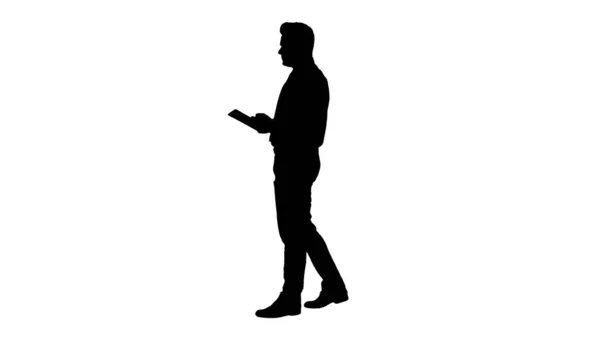 Silhouette Elegante joven hombre de negocios usando la tableta mientras camina. — Foto de Stock