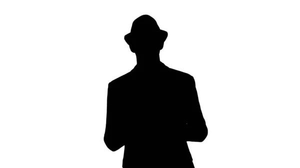 Silhouette Lässiger Mann mit Hut geht und zeigt Digitalkamera Tablet. — Stockfoto
