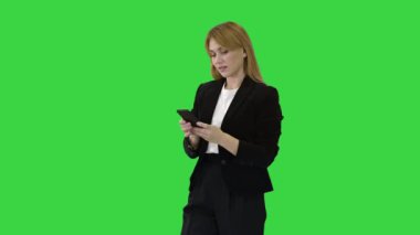 Güzel ve mutlu, gülümseyen genç iş kadını Yeşil Ekran, Chroma Key 'de telefon uygulaması ile etkileşime geçiyor..