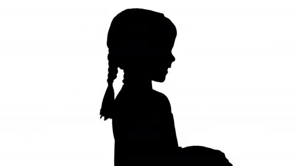Silhouette Lächelndes kleines Mädchen spielt Videospiel mit Steuerknüppel in der Hand. — Stockvideo