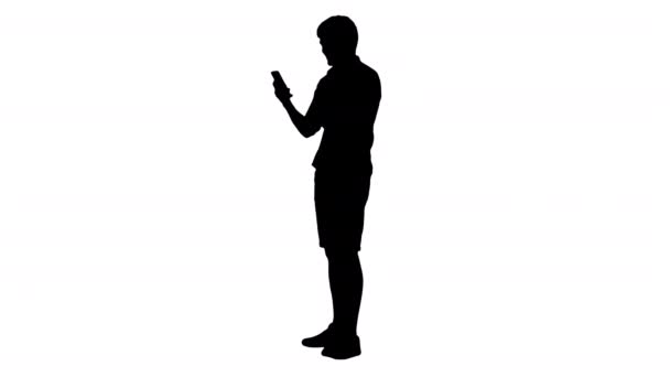 Silhouet Knappe jongeman met behulp van zijn smartphone en lachen. — Stockvideo