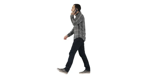 Молодий бородатий чоловік ходить і розмовляє по мобільному телефону на — стокове фото