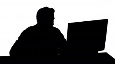 Siluet Ciddi oyuncu bilgisayar başında oturmuş maç izliyor.