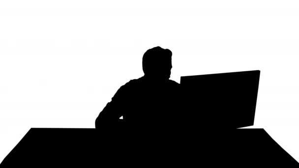 Silhouette Seriöser Gamer sitzt am Computer und beobachtet ein Spiel. — Stockvideo