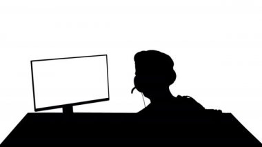 Bilgisayarda online oyunlar oynayan rekabetçi genç adamın arka plandaki silueti.