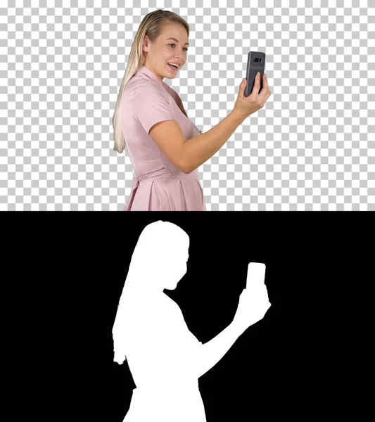 Feminino em vestido rosa fazendo videochamada com seu telefone inteligente, Alp — Fotografia de Stock