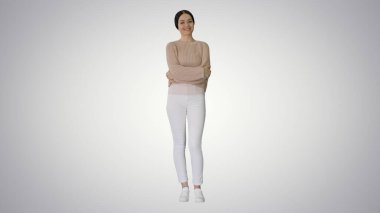 Gülümseyen genç kadın kollarını kavuşturup sırt üstü yatıyor.