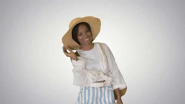Sorridente giovane donna afroamericana in un cappello di paglia in posa su gr — Foto Stock