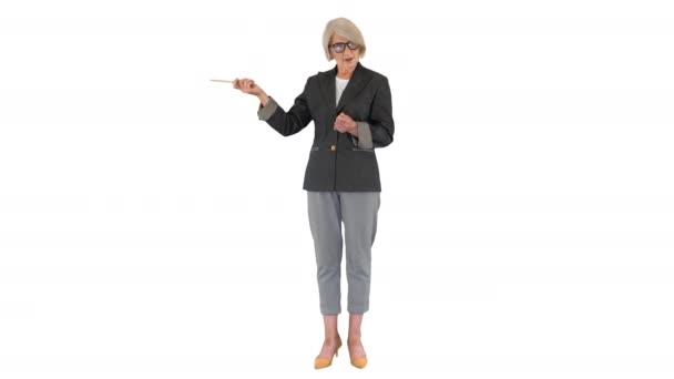 Fiducioso anziana signora insegnante spiegando e indicando qualcosa su sfondo bianco. — Video Stock