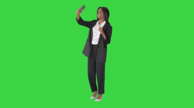 Güzel Afrikalı amerivan kadın yeşil ekranda, Chroma Key 'de telefonuyla selfie çekiyor..