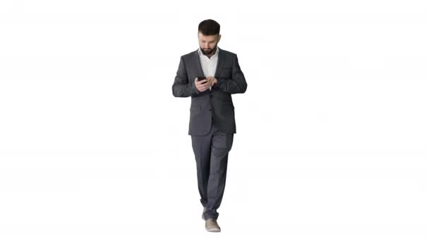 ビジネスマンは白い背景に携帯電話を使用して歩く. — ストック動画