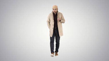 Trençkotlu genç adam konuşuyor. Güvenle kameraya konuşuyor.