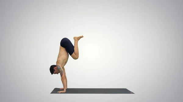 Joven haciendo yoga sobre fondo de gradiente. — Foto de Stock