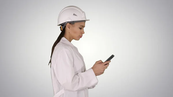 Inżynier korzystający z telefonu komórkowego smsowania podczas chodzenia po gradiencie ba — Zdjęcie stockowe