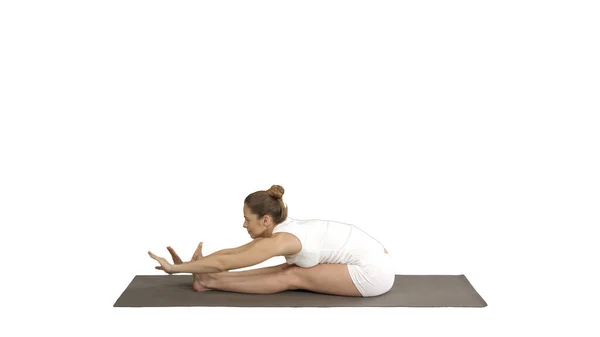 Молодая спортивная привлекательная женщина практикующая йогу, занимающаяся сидячим передним изгибом, позирующая пасхимоттанасана, занимающаяся спортом, носящая спортивную одежду на белом фоне. — стоковое фото