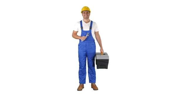 Un reparador sosteniendo una caja de herramientas y una llave sonriente a la cámara sobre fondo blanco. — Foto de Stock