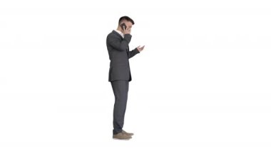 Takım elbiseli bir iş adamı beyaz arka planda cep telefonuyla konuşuyor..