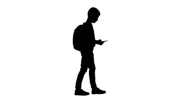 Silhouette Schoolboy mit einem Rucksack mit Handy, während wa — Stockfoto