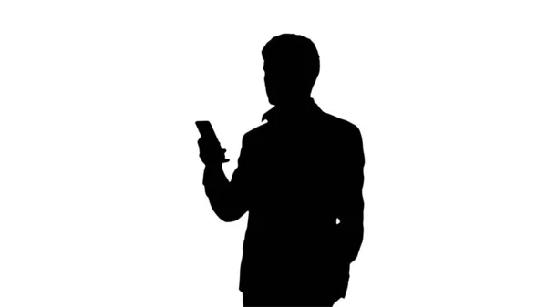 Silhouette Серйозний бізнесмен дивиться на свій телефон . — стокове фото