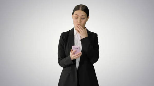 Mujer de negocios que mira desaprobadamente usando su teléfono en gradien — Foto de Stock