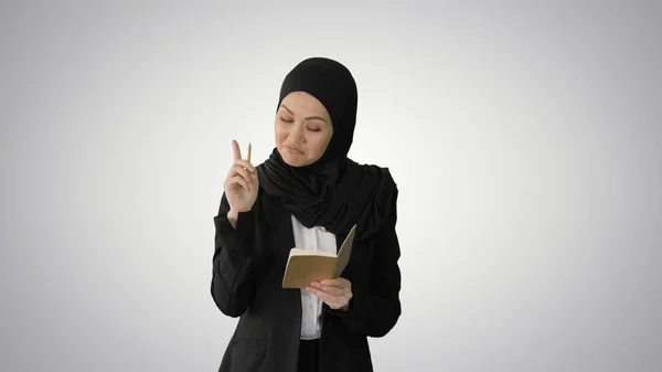 Muslimische Geschäftsfrau denkt und schreibt Ideen in ihren Notizblock — Stockfoto