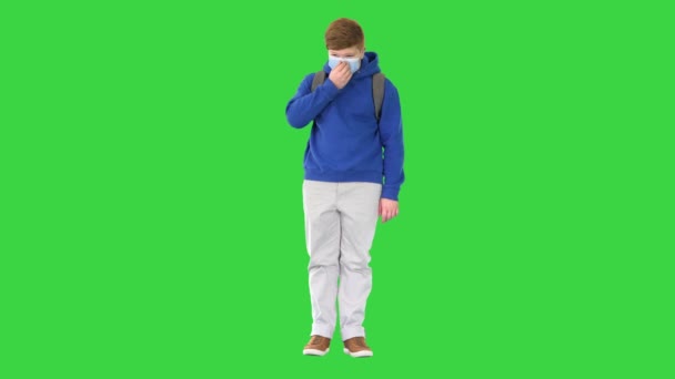 Cool adolescente menino em roupas casuais usando máscara médica em uma tela verde, Chroma Key. — Vídeo de Stock