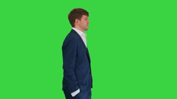 Joven empresario confiado caminando con las manos en los bolsillos en una pantalla verde, Chroma Key. — Vídeos de Stock